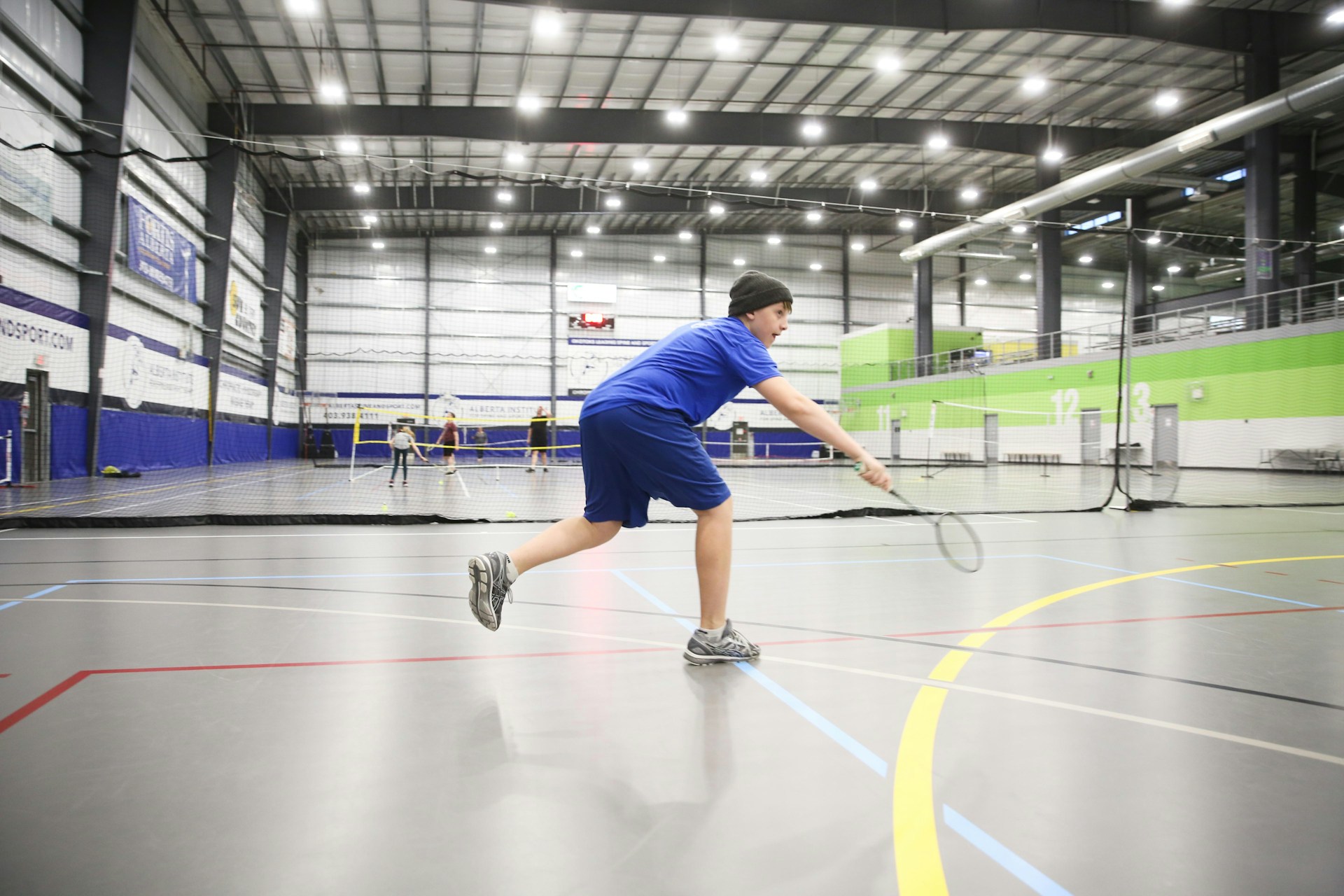 Jeune joueur sur un terrain de badminton